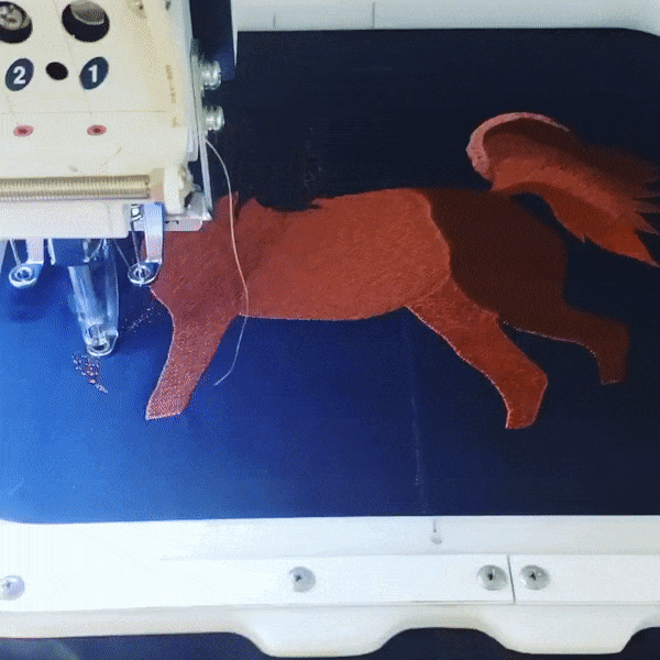 Embroidery Gif: Horse Design being embroidered onto a blue fabric using an embroidery machine at earthbound inc in grand rapids michigan. 
